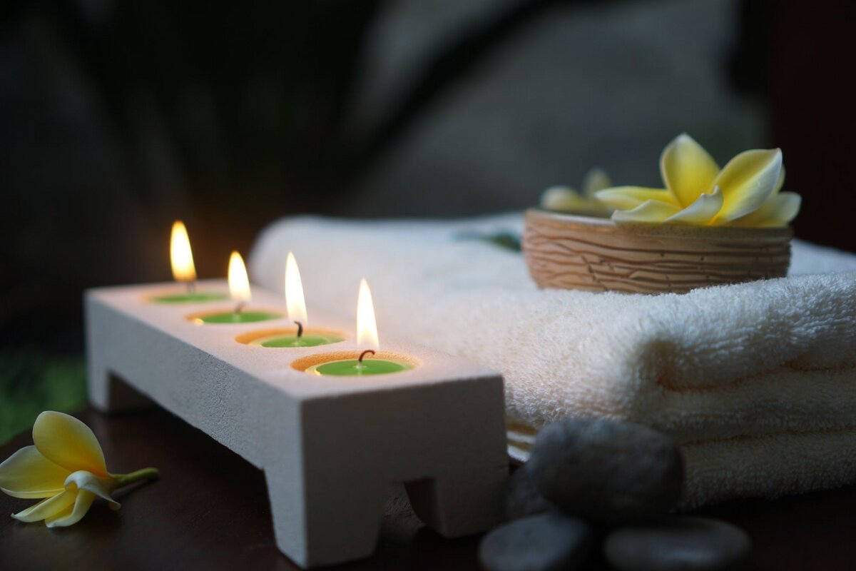 Candles, a folded towel and frangipani