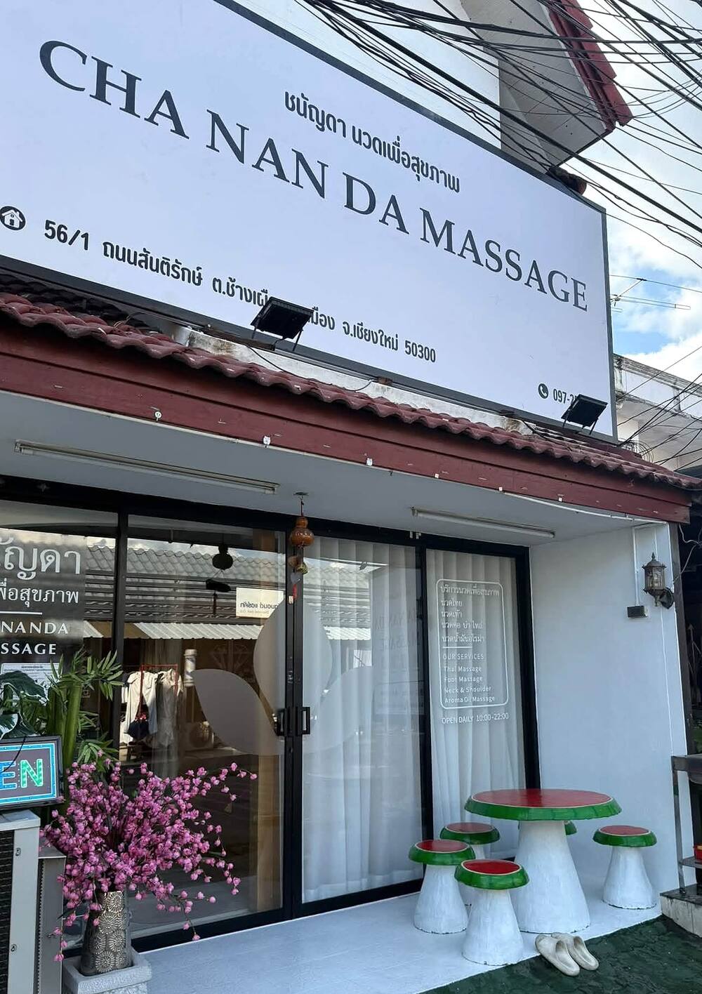 Chananda Massage's doorway on Santirak Road: the white CHA NAN DA MASSAGE sign, the OPEN sign and the glass doors